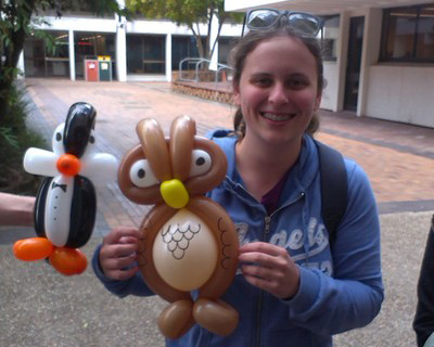 a photo of a girl holding a balloon penguin and balloon owl